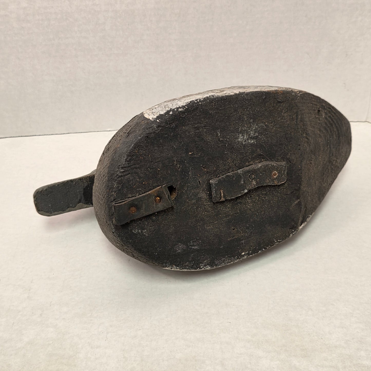 Black leather shoe with a strap on a light gray background