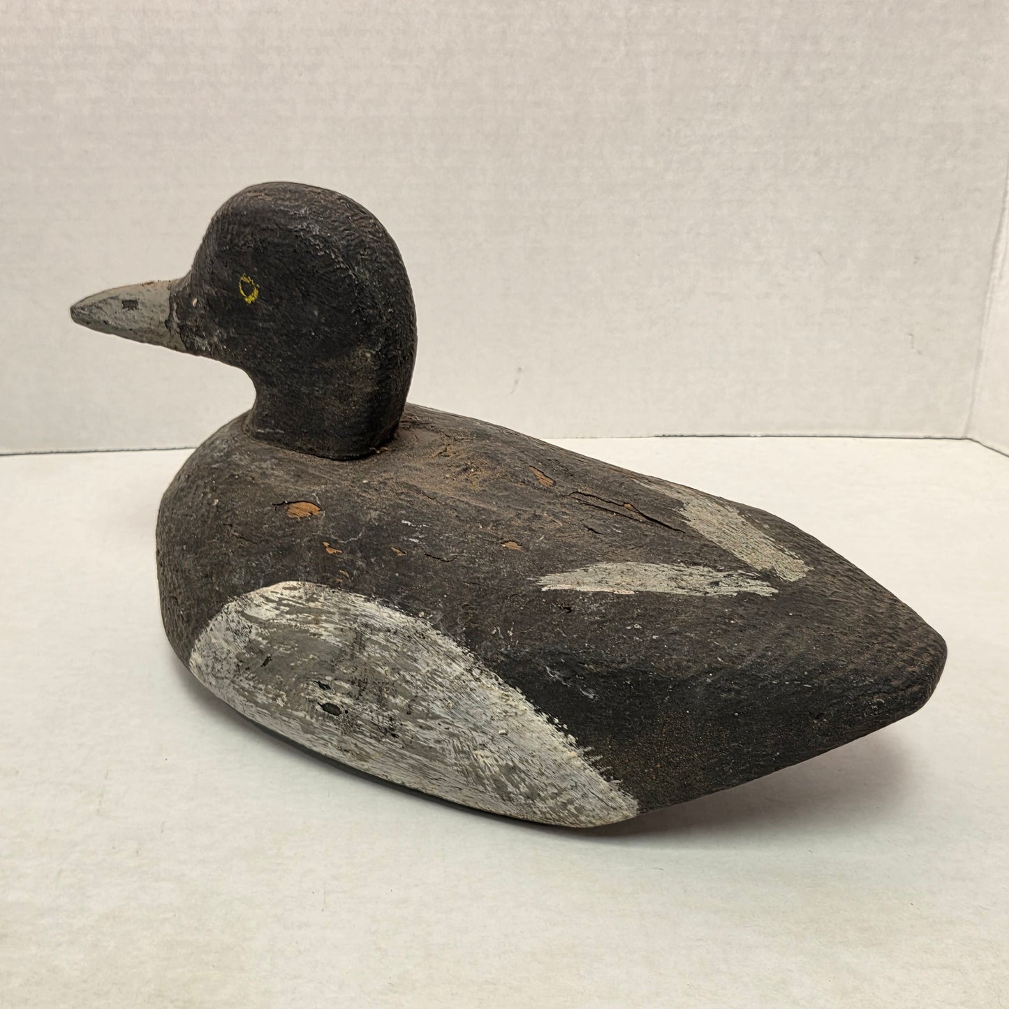 Wooden duck decoy on a light gray background