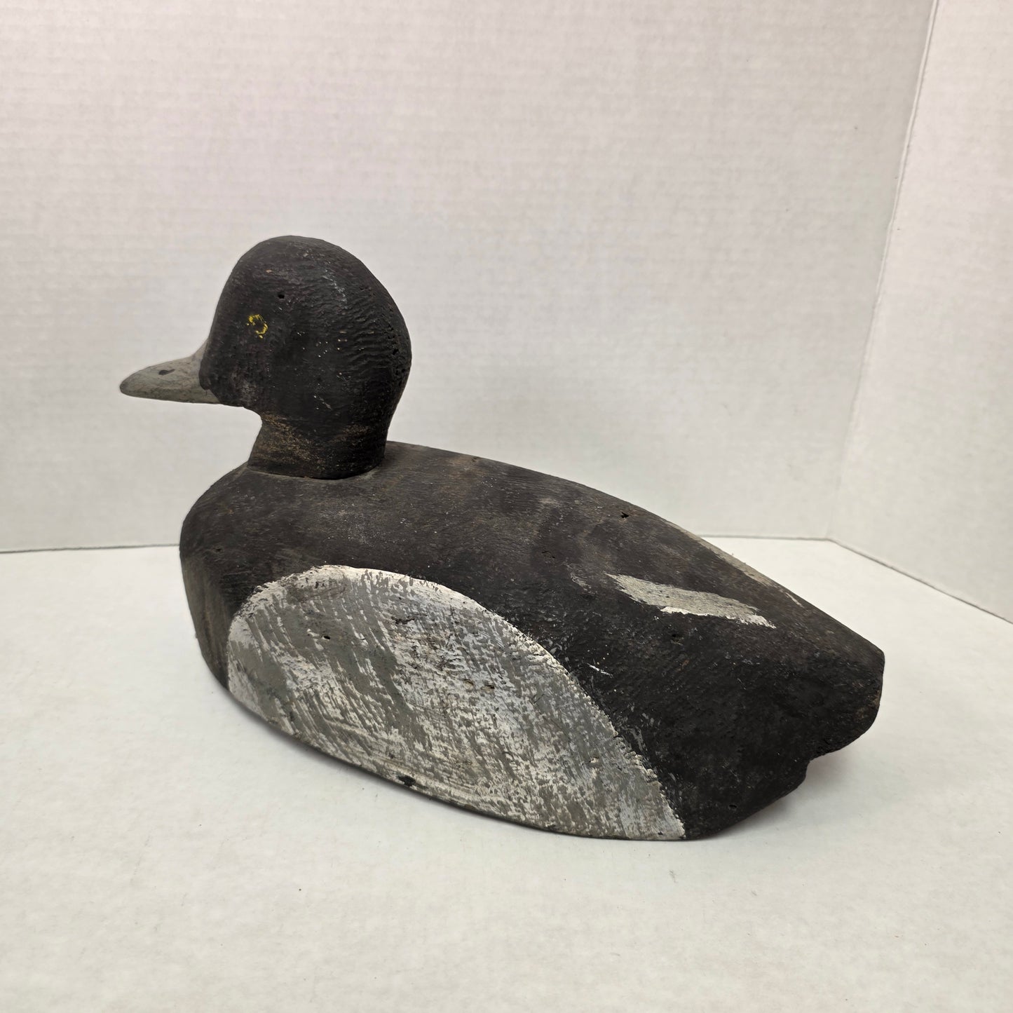 Black and gray duck decoy on a white background
