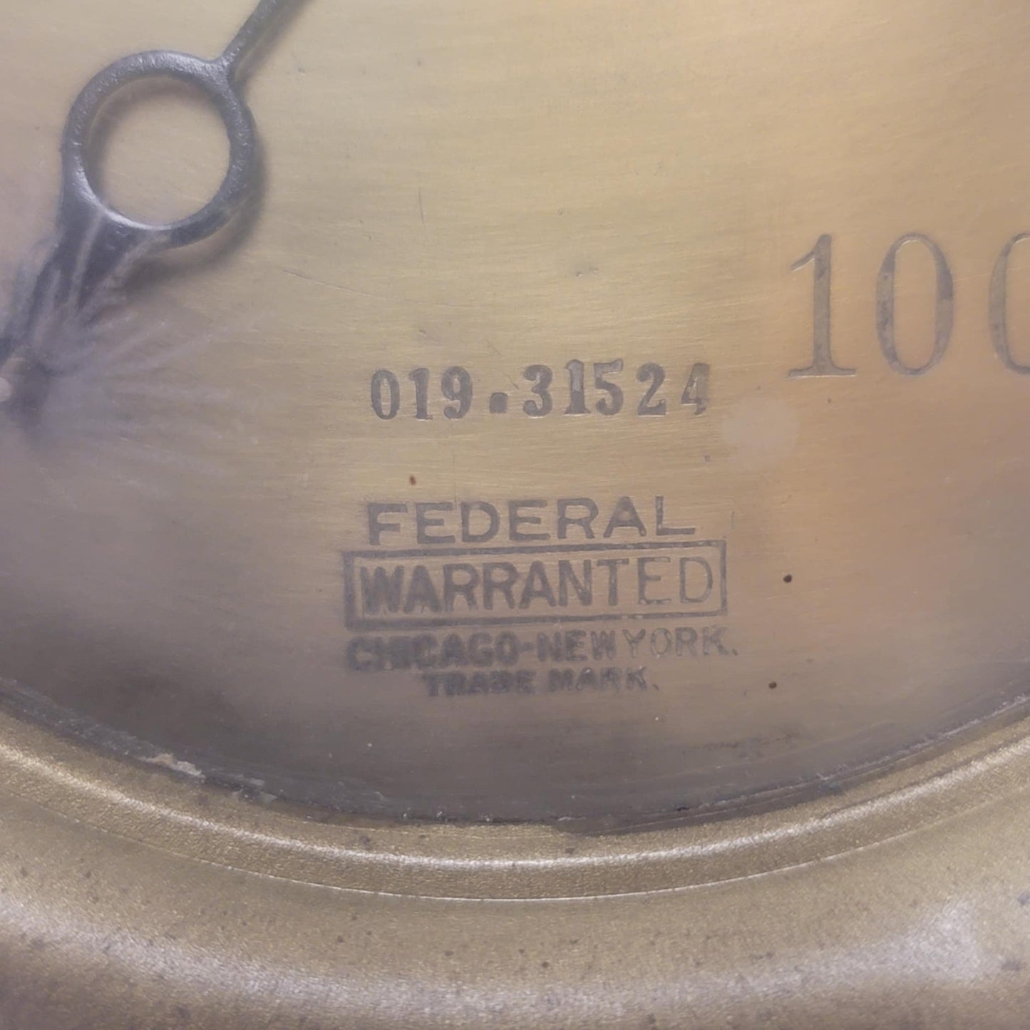 Close-up of a metal object with 'Federal Warranted' branding and numbers.