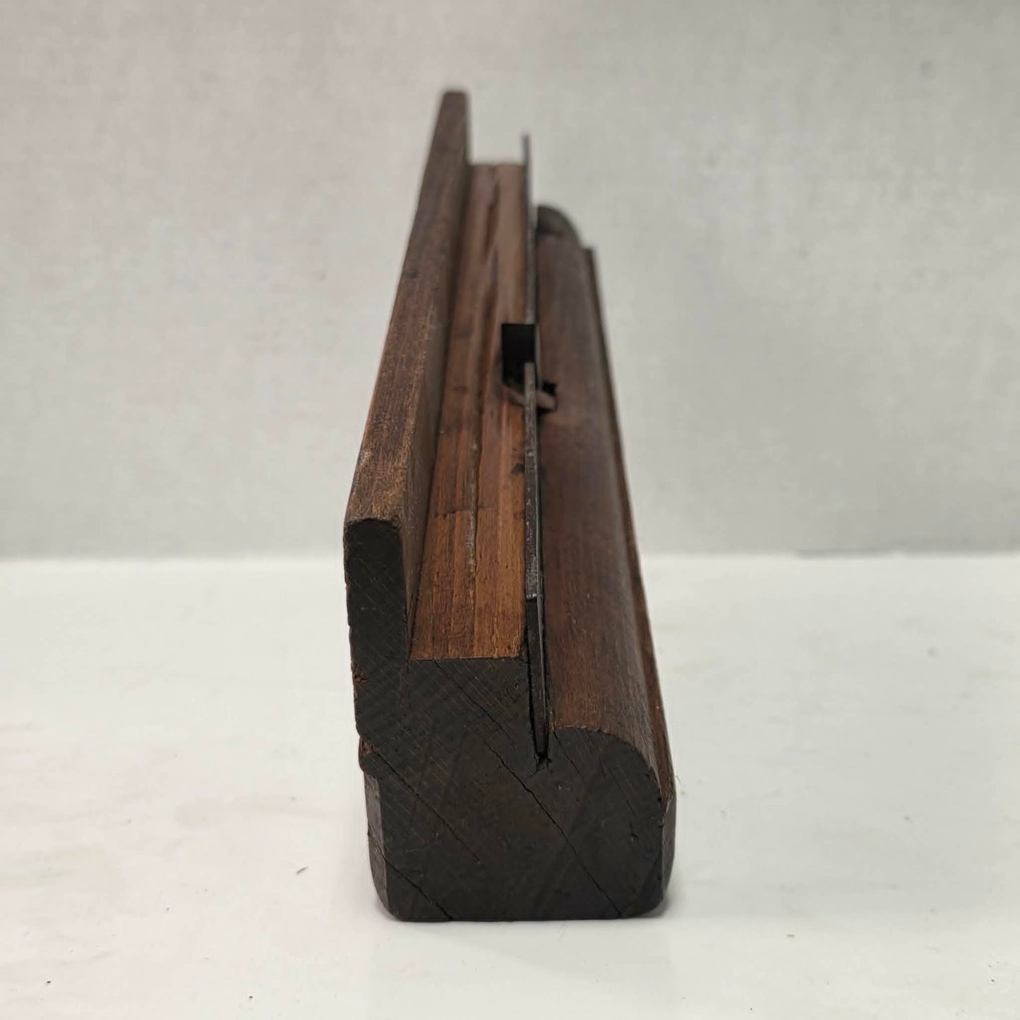 Antique wooden grooving plane with steel rail for tongue and groove woodworking.