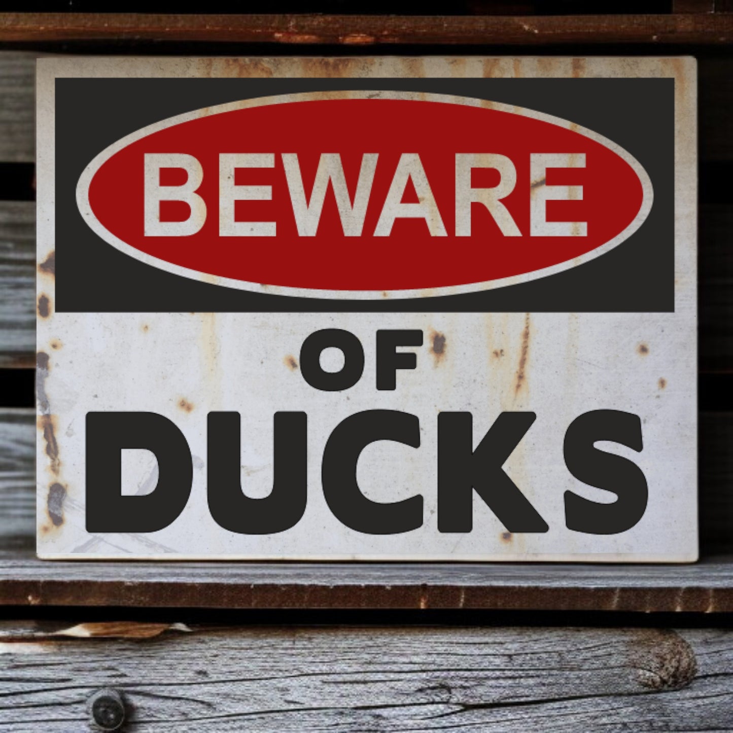 Vintage-style 'Beware of Ducks' sign with rust and wear on a wooden surface.