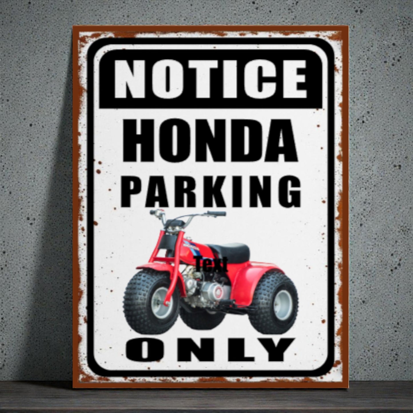 Metal sign with red ATV graphic and text 'Notice Honda Parking Only' on a textured wall background