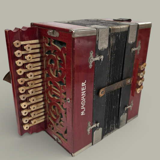 Red and black M. Hohner accordion on a gray background