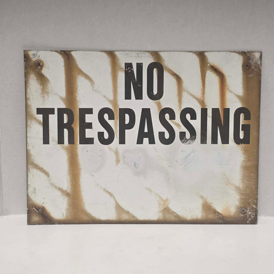 Original vintage weathered No Trespassing metal sign with natural aged patina.