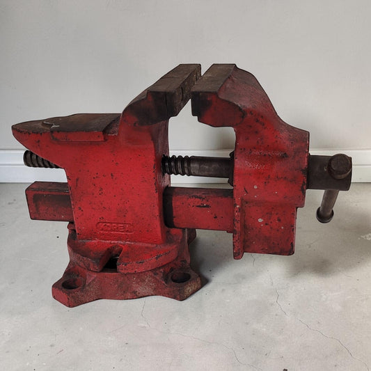 Vintage cast iron swivel base bench vise with 4-inch jaws and rear anvil.
