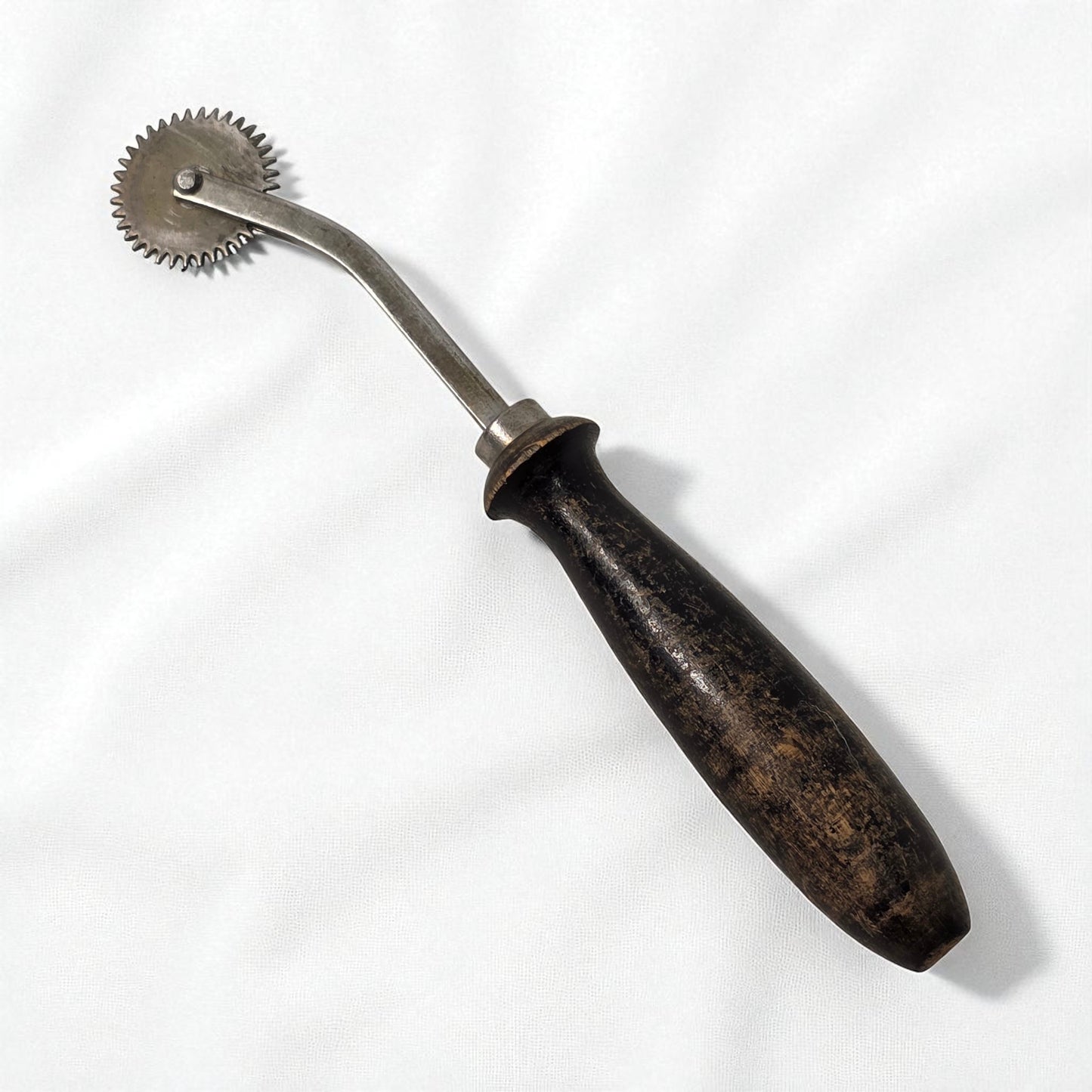 Vintage metal tool with wooden handle on a white background