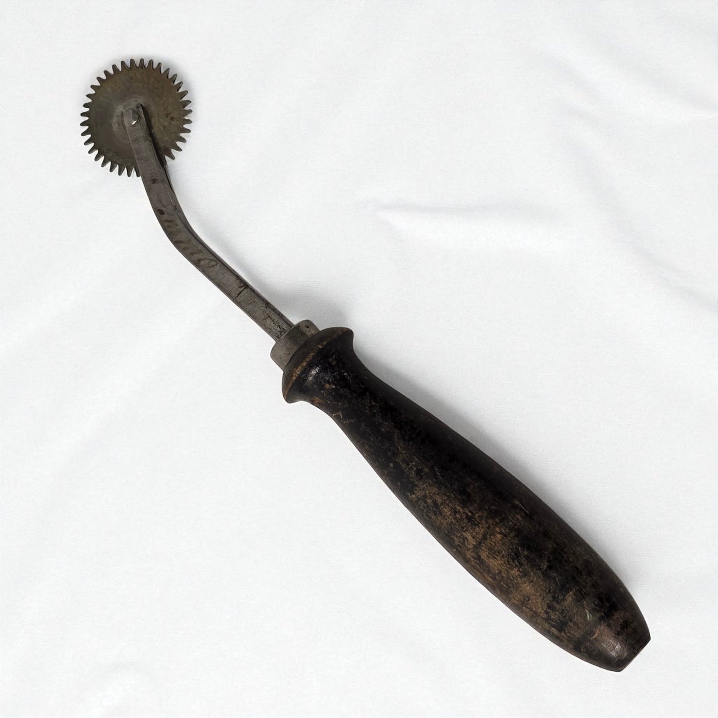 Vintage metal tool with a handle on a white background