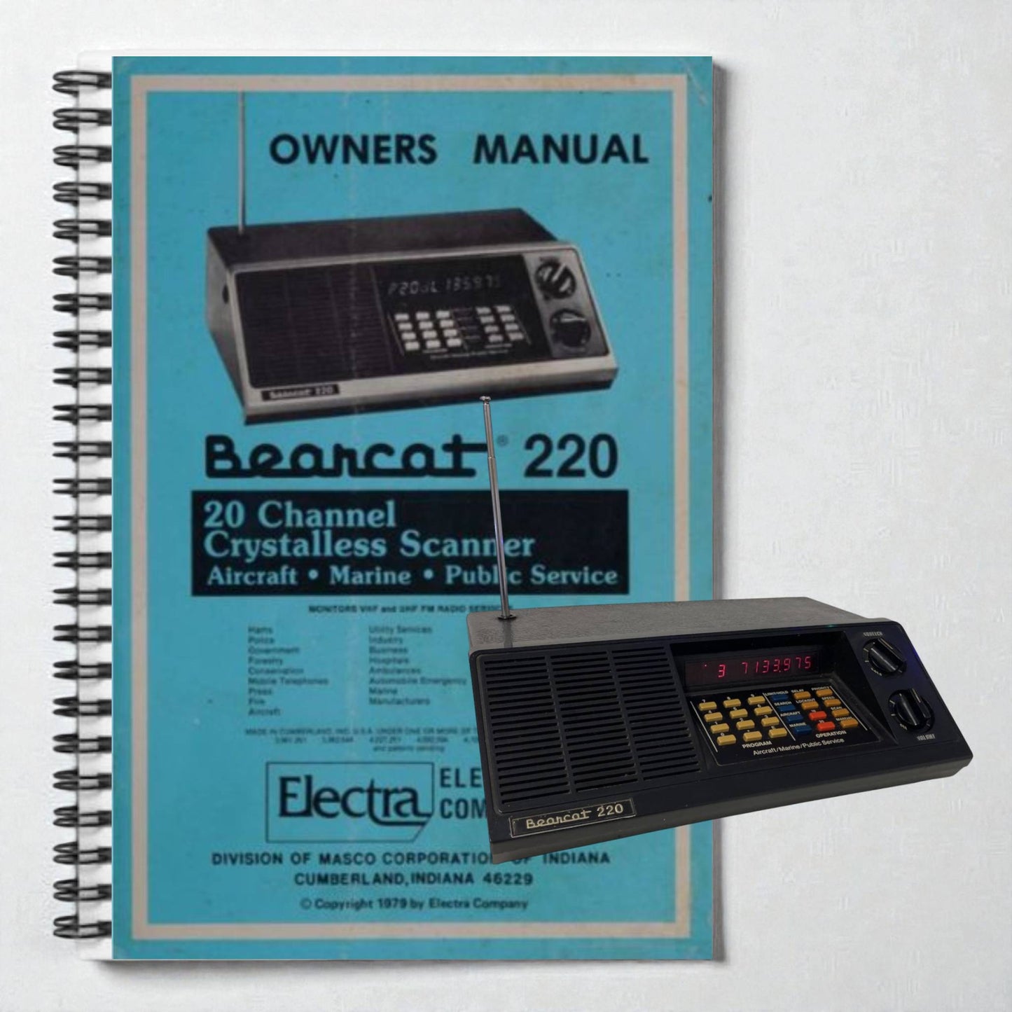 Vintage Bearcat 220 scanner with its owner's manual on a light gray background