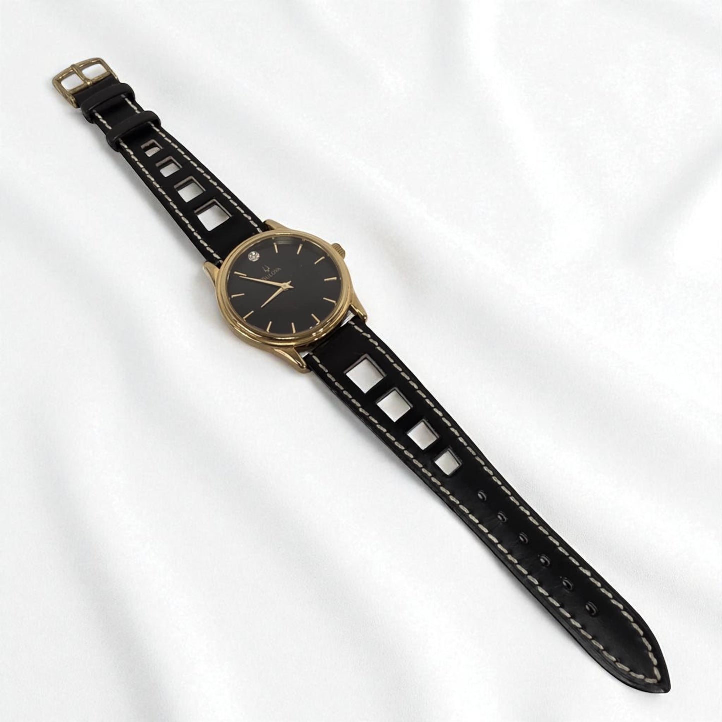Black watch with gold case on a white background