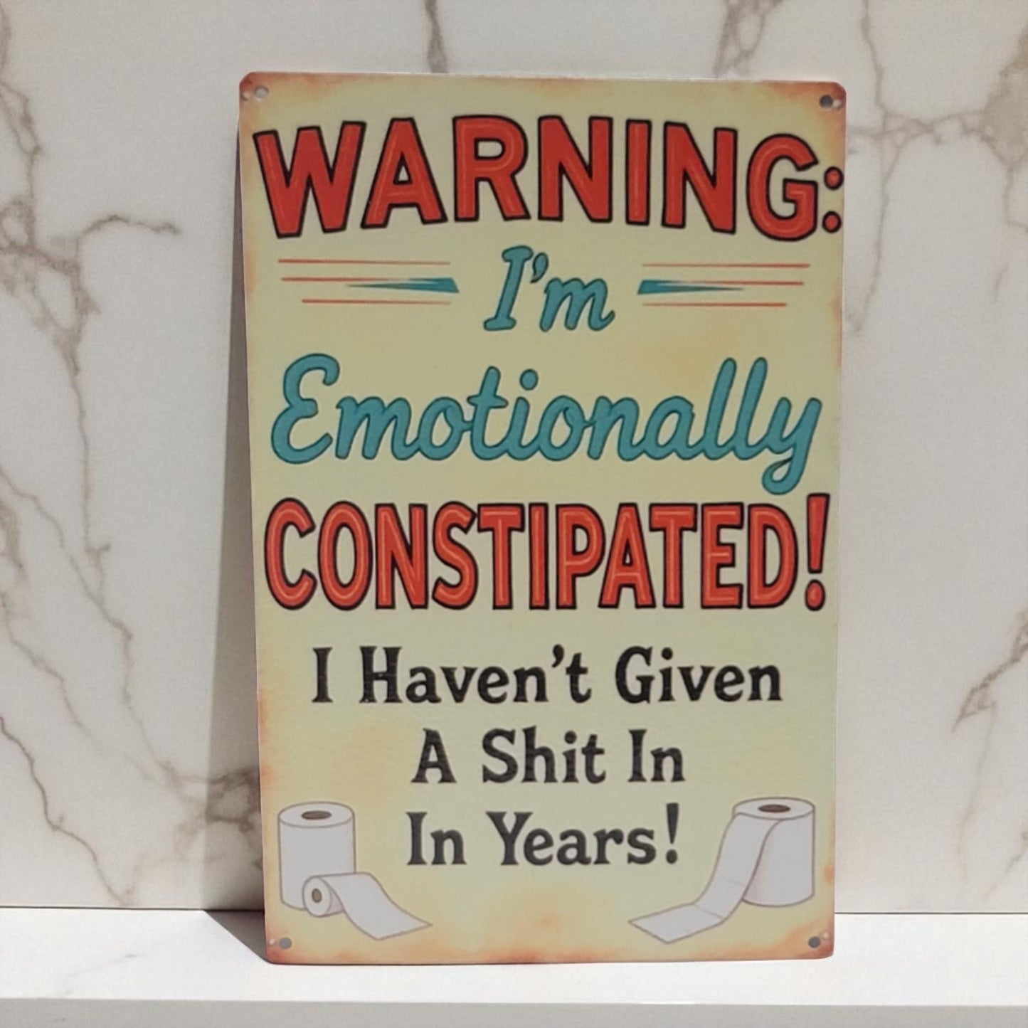 Metal sign with humorous text and toilet paper graphics on a marble background
