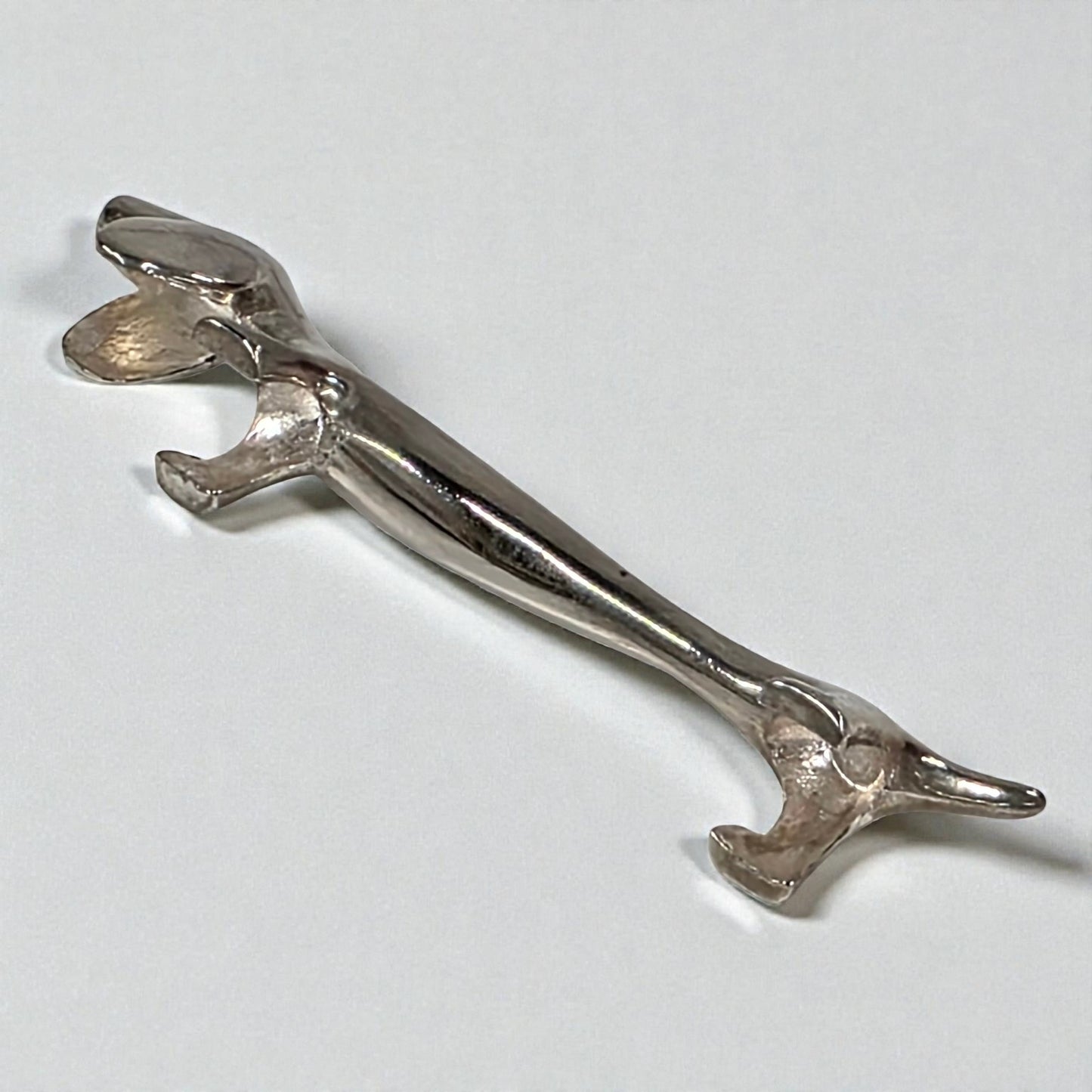 Silver dachshund dog knife holder on a light gray background