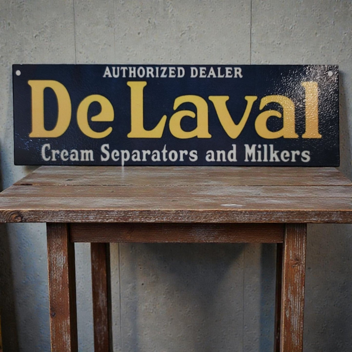 Vintage-style sign for DeLaval cream separators and milkers on a wooden table.