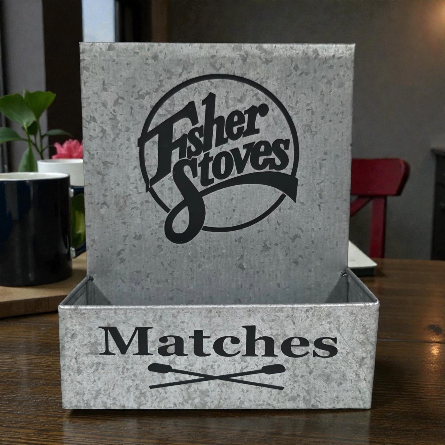 Matches box with Fisher Stoves logo on a wooden surface