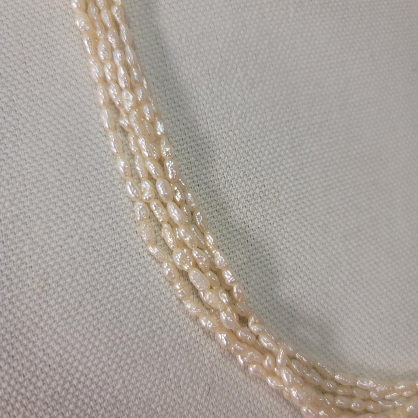 Close-up of a beaded necklace on a light gray fabric background