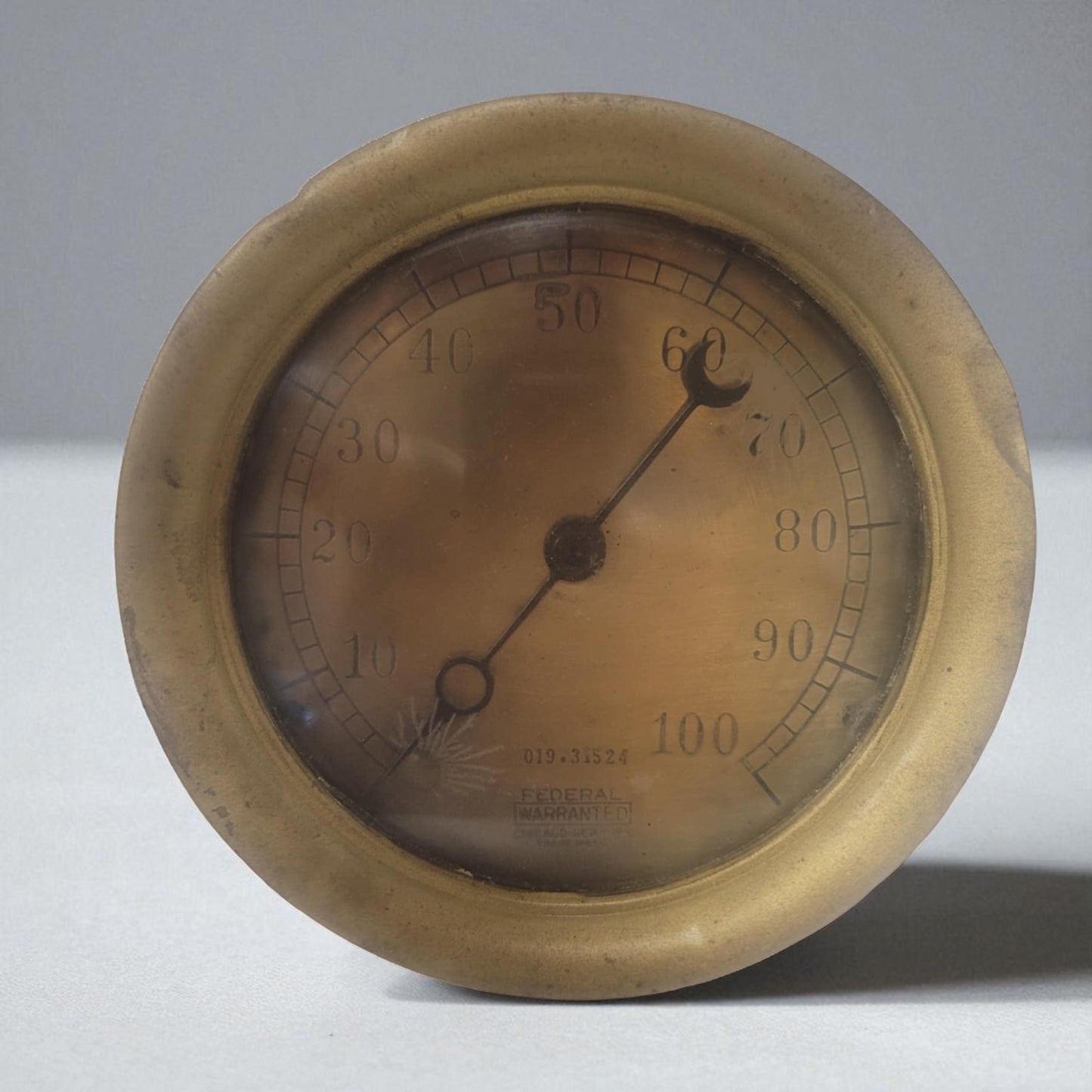 Vintage brass thermometer on a white background