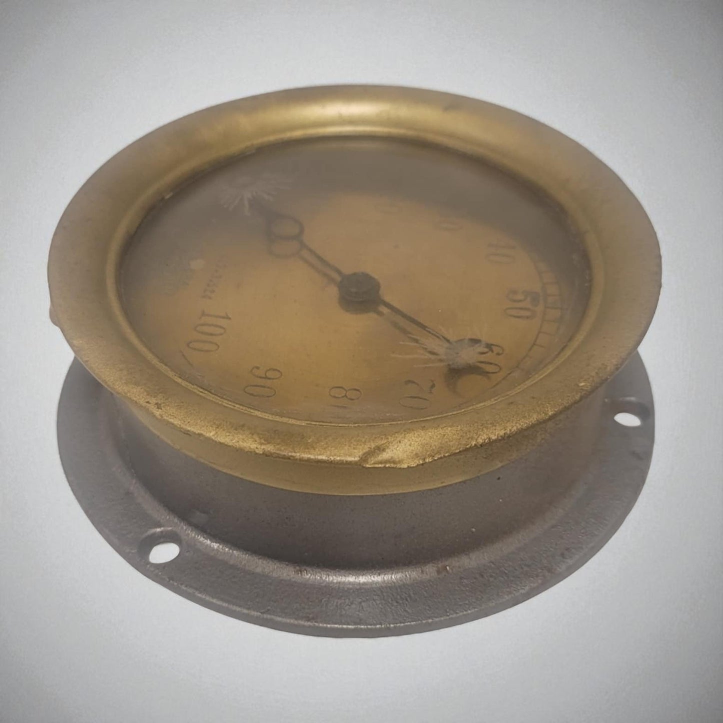 Bronze pressure gauge on a gray background