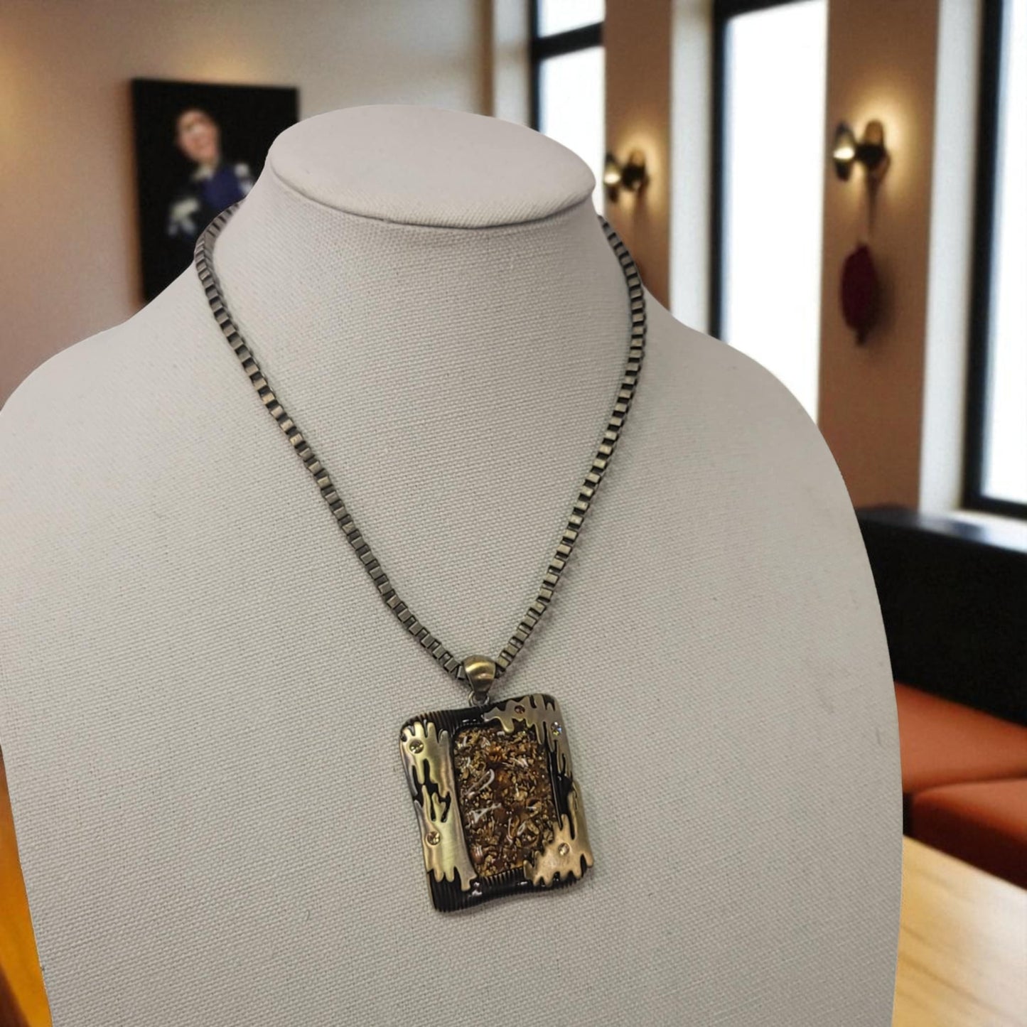 Necklace with a decorative pendant on a mannequin bust in an indoor setting