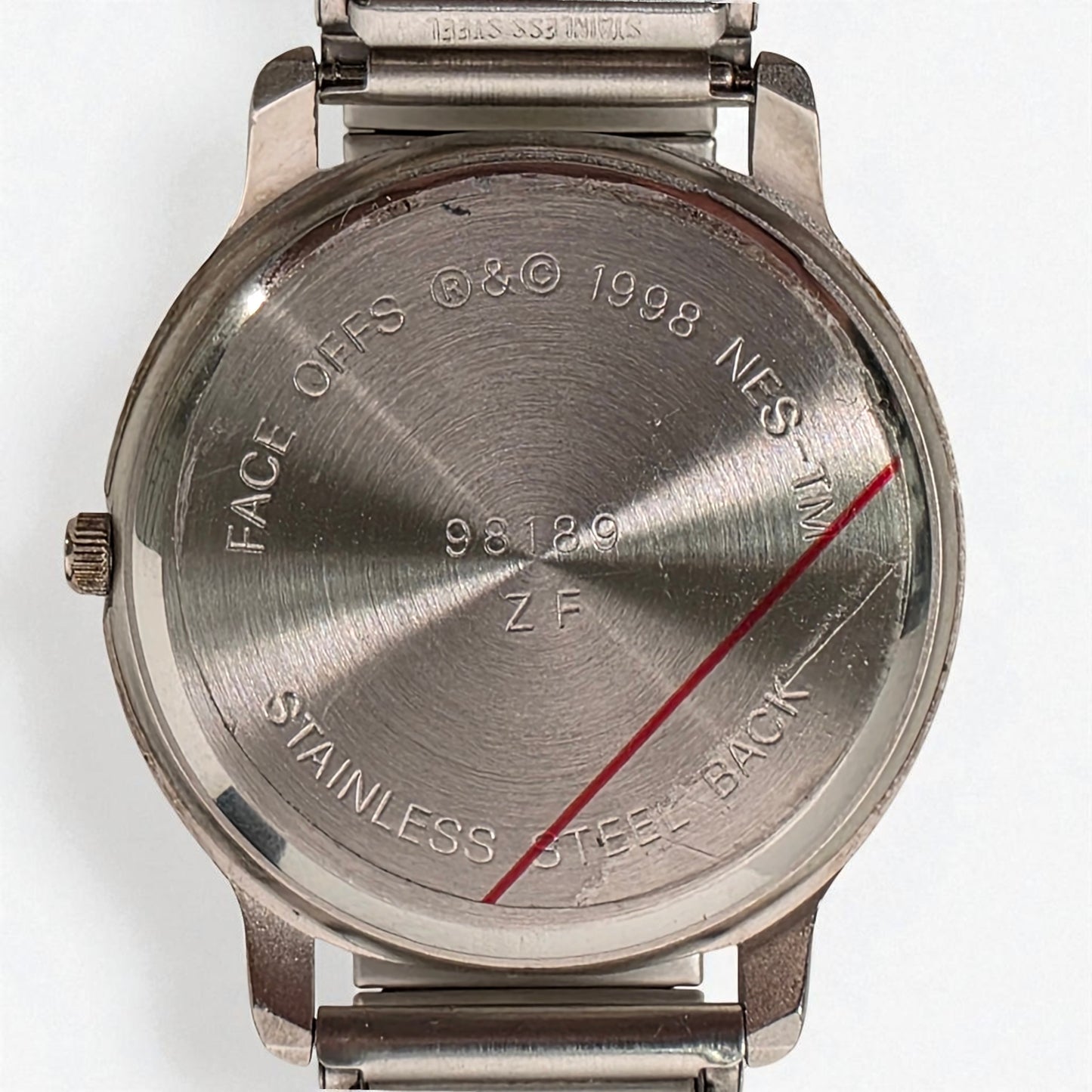 Back view of a stainless steel watch with engraved text on a white background