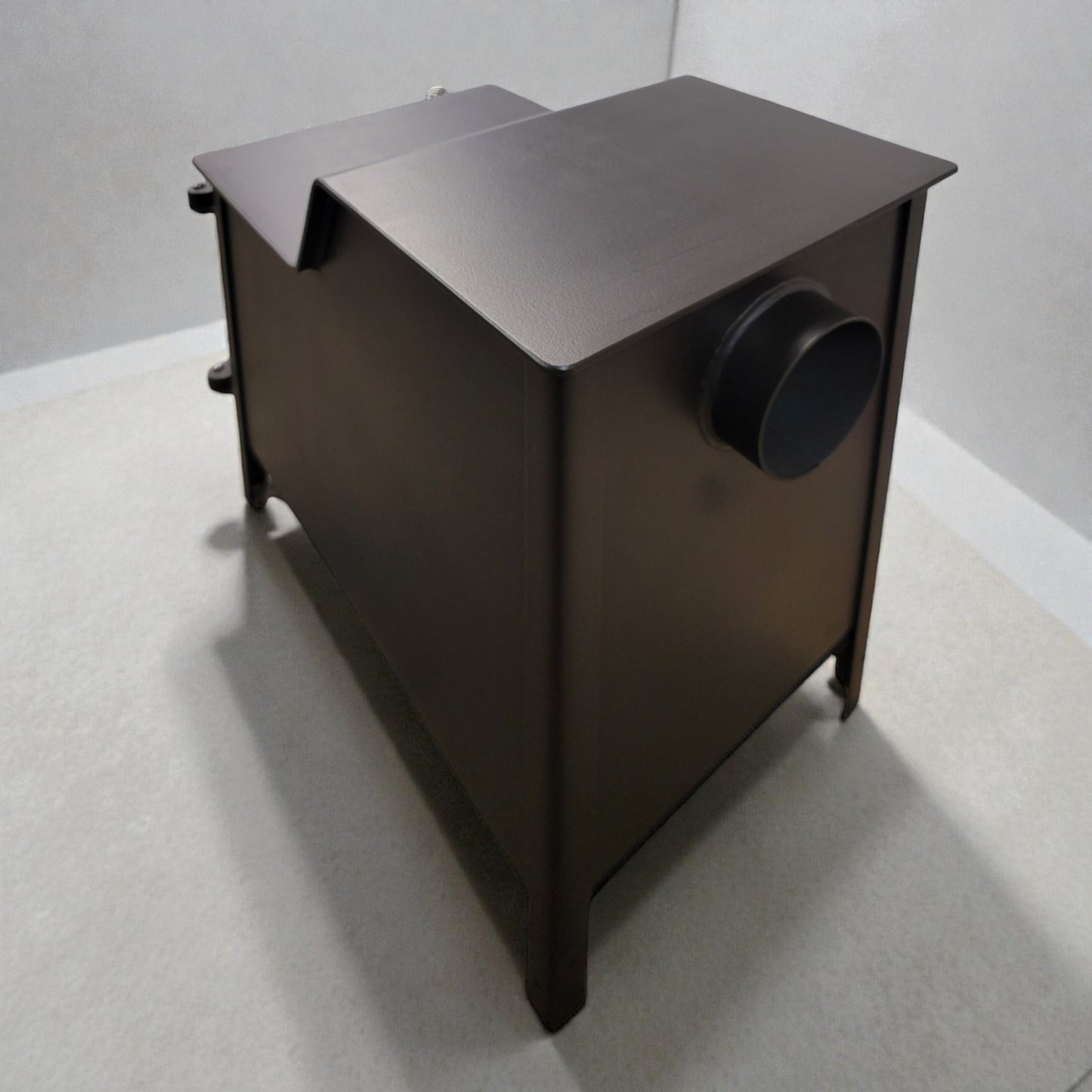Black metal cabinet with a round vent on a gray floor and white wall background