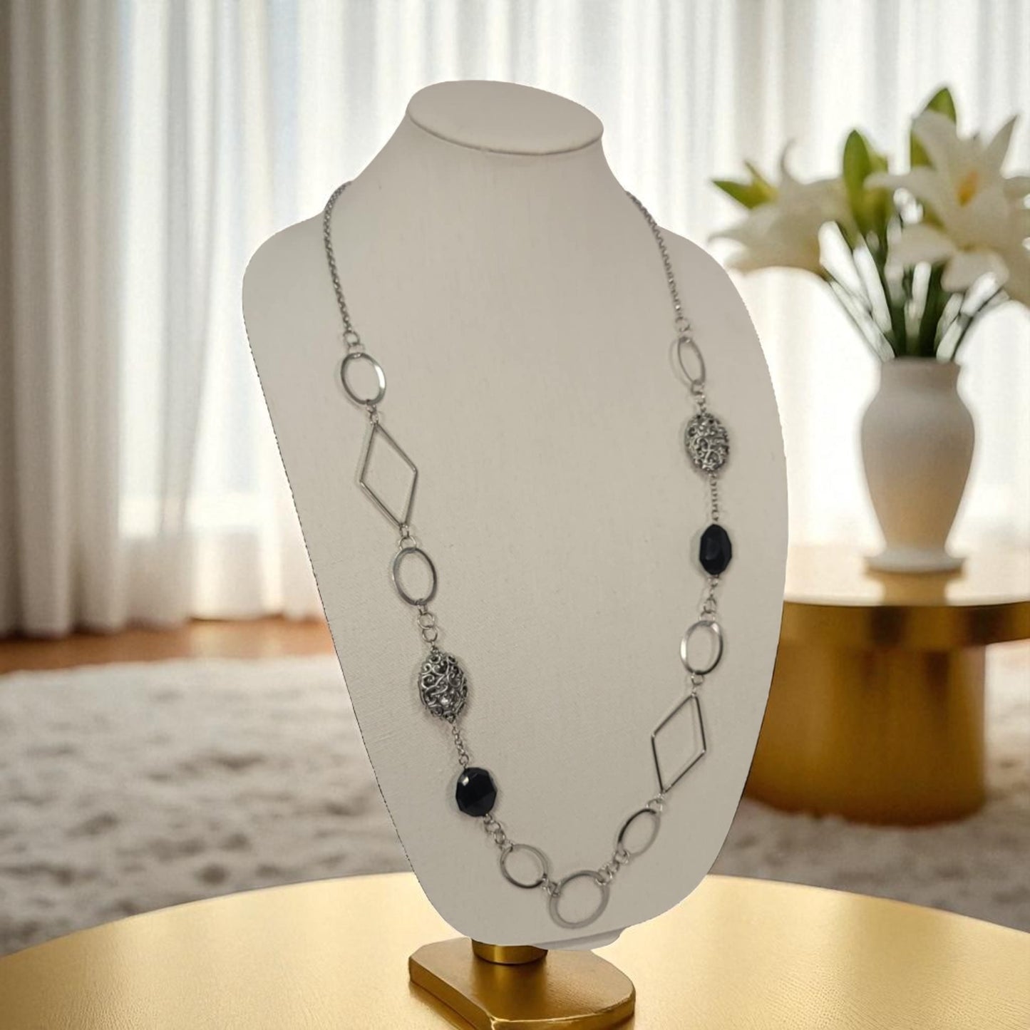 Necklace on a white bust with a blurred indoor background