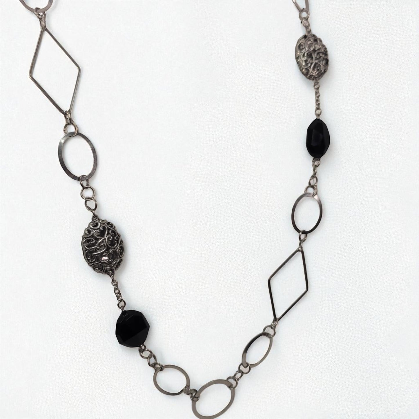 Necklace with geometric metal links and black beads on a white background