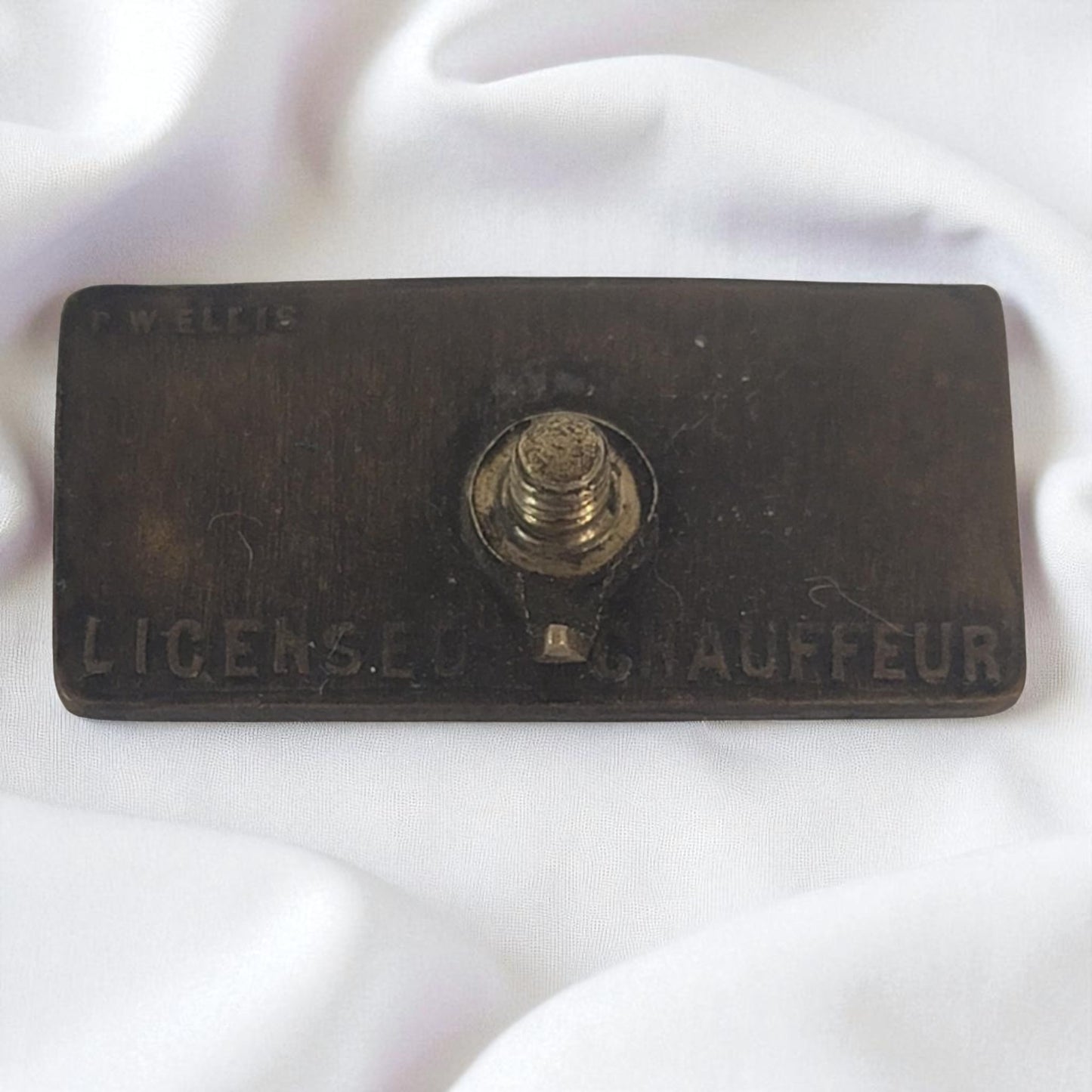 Vintage 'License Chauffeur' badge on a white background
