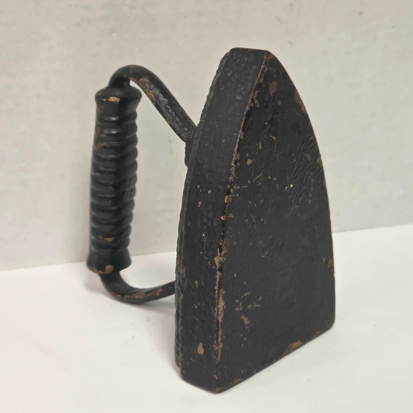 Primitive antique cast iron sad iron with nicely formed handle and vintage finish.