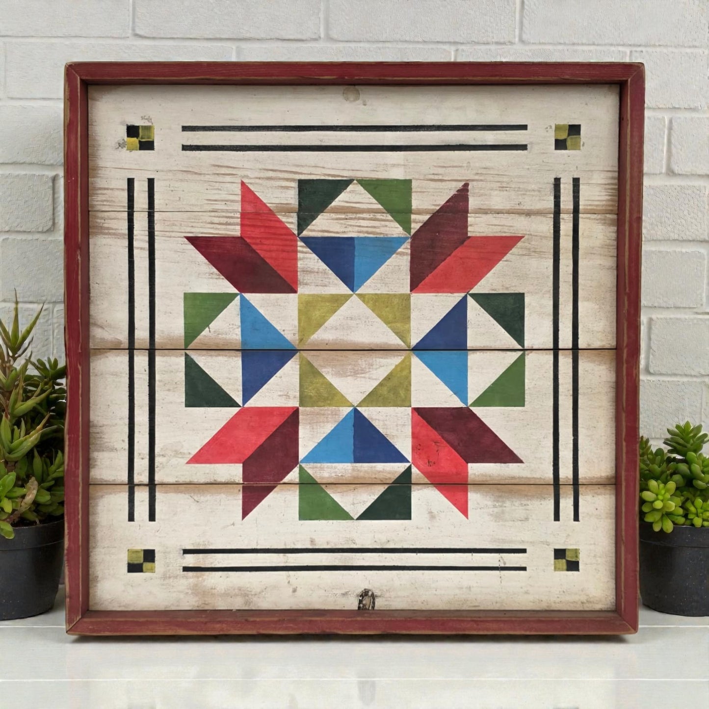 Wooden wall art with geometric pattern in a wooden frame on a white brick wall background.