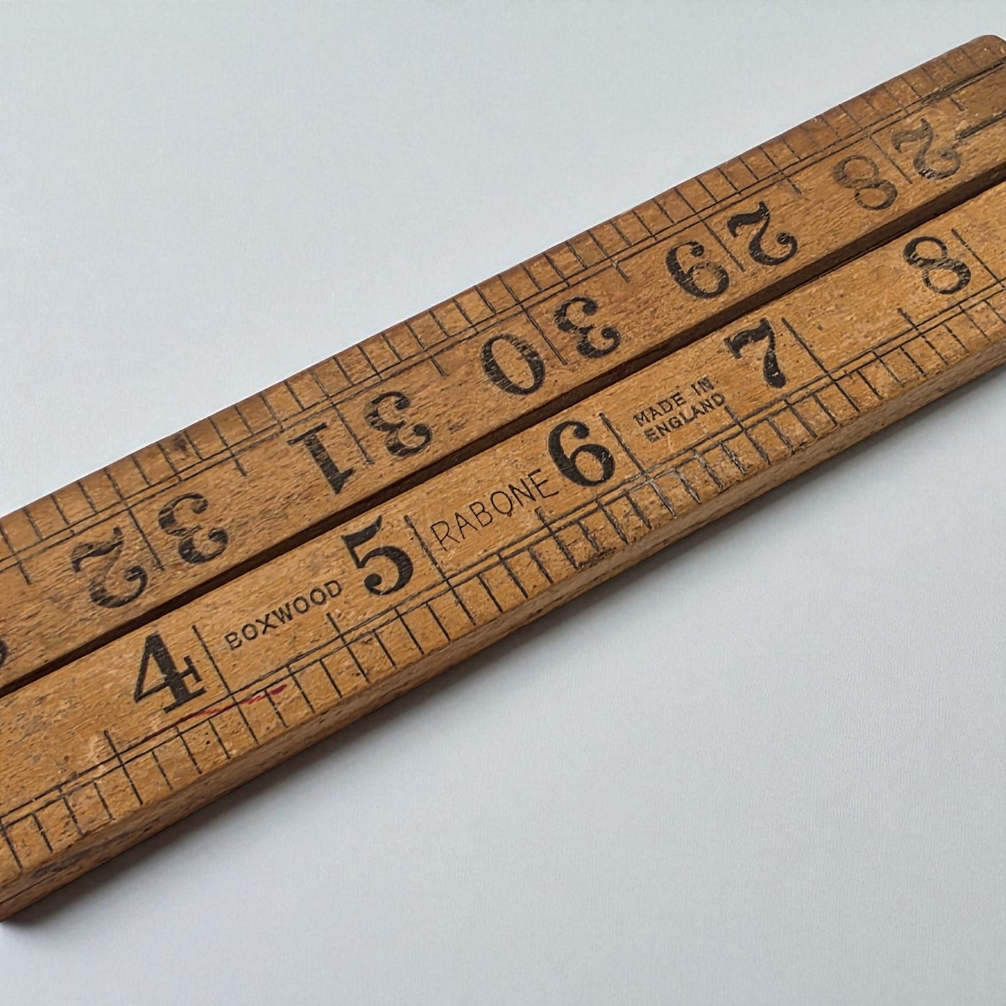 Wooden ruler with measurement markings on a light gray background