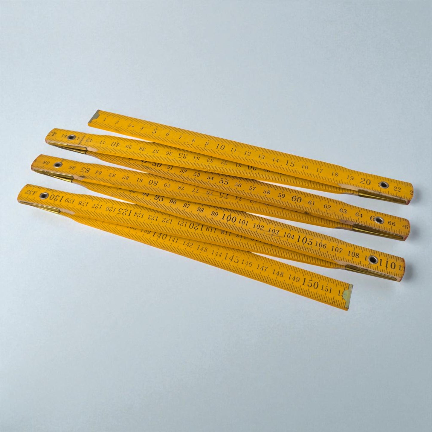 Set of yellow metal rulers on a light gray background