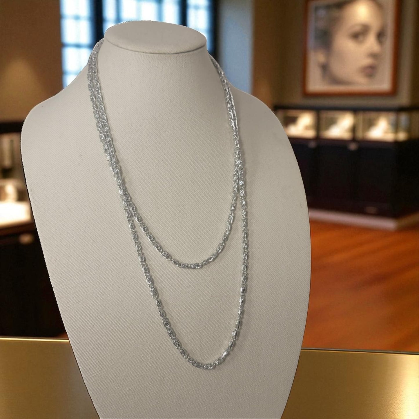 Silver chain necklace on a mannequin bust with a blurred indoor background