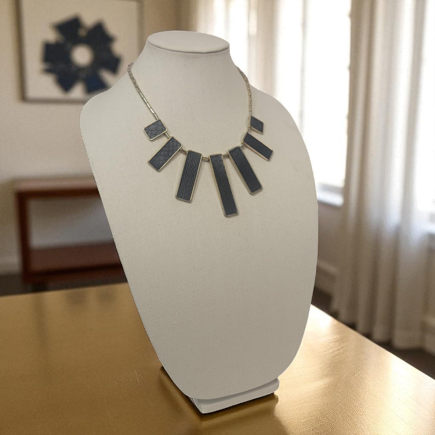 Necklace on a mannequin bust with a blurred indoor background