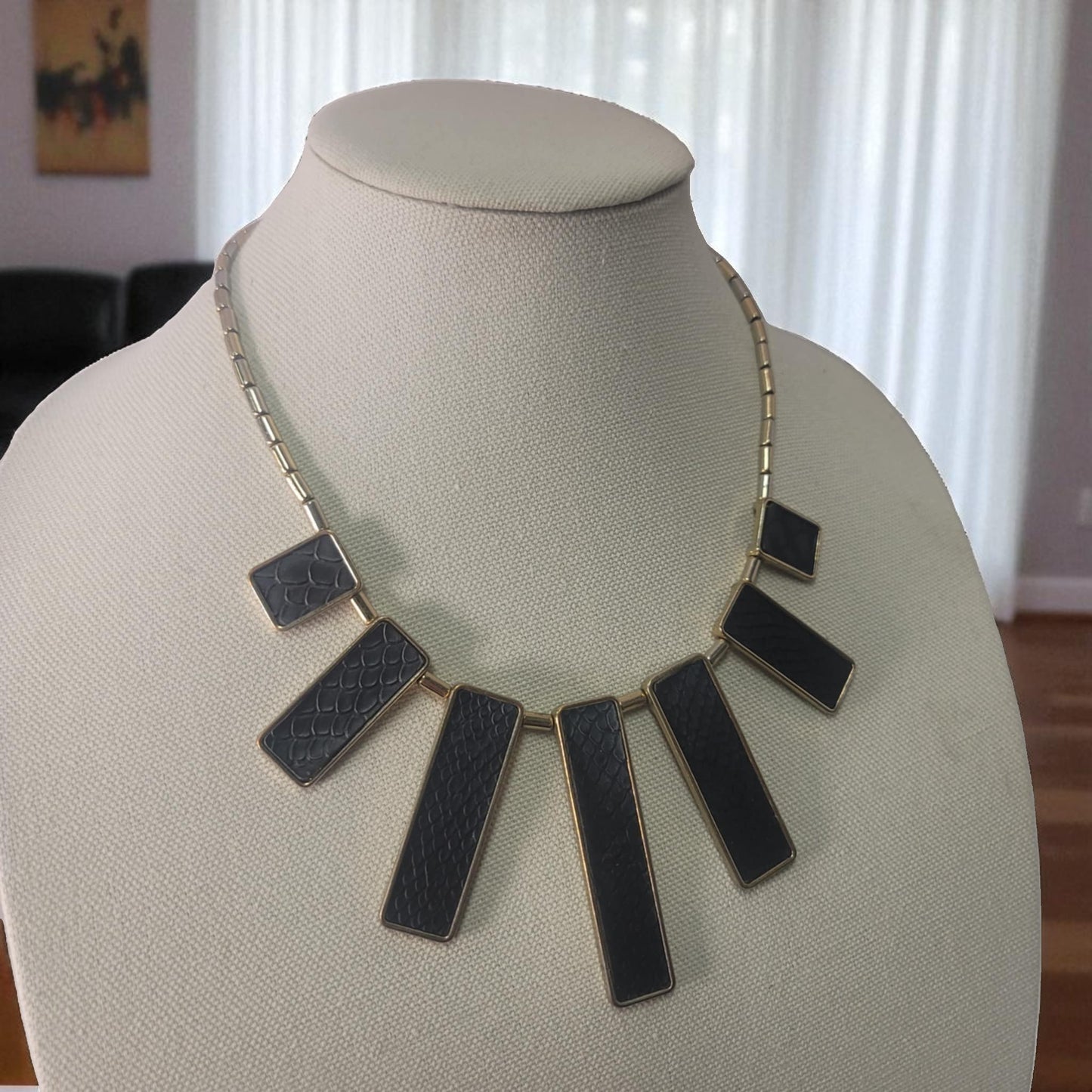 Necklace with black rectangular pendants on a mannequin bust.