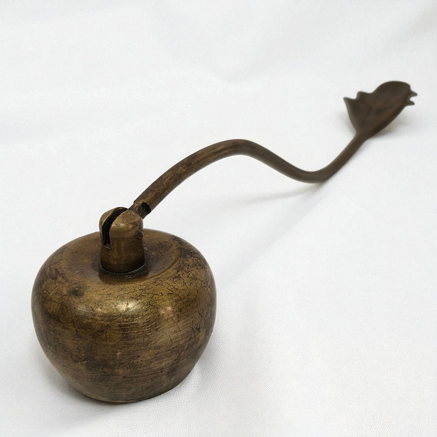 Bronze oil lamp with a long spout on a white background