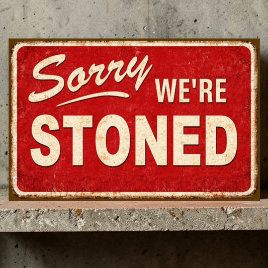 Red sign with 'Sorry WE'RE STONED' text on a concrete wall background