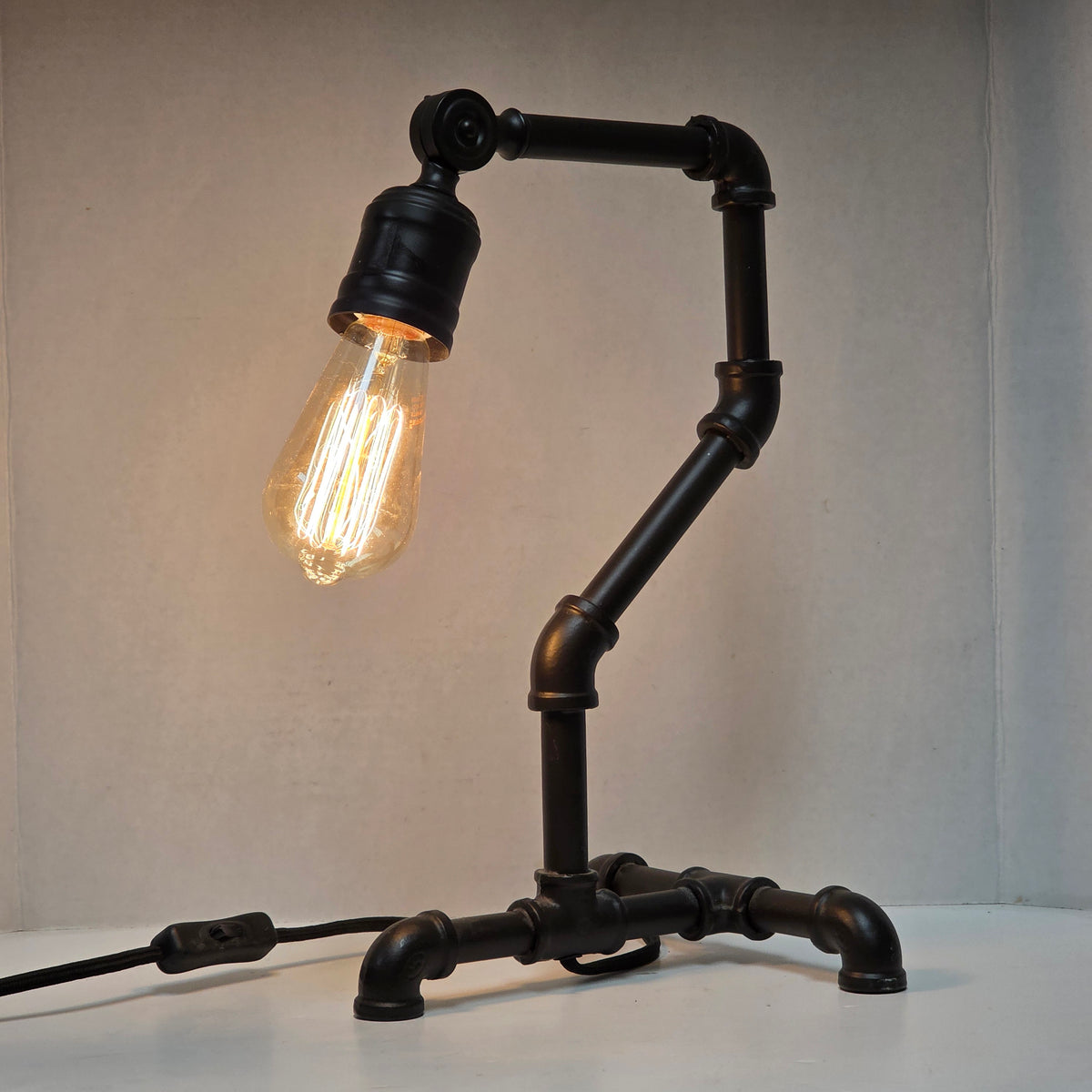Industrial steampunk desk lamp featuring retro plumbing pipe design and Edison bulb