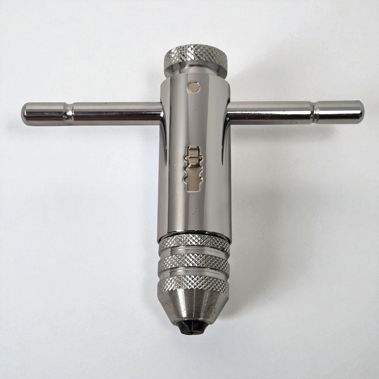 Metal drill bit and wrench on a white background