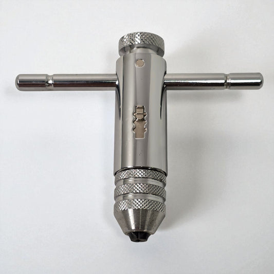 Metal drill bit and wrench on a white background