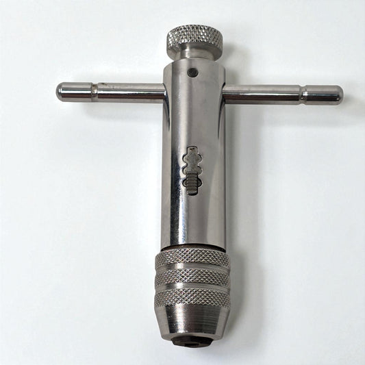 Metal t-handle tool on a white background