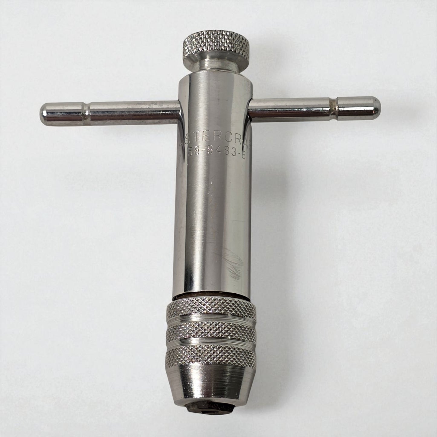 Metal t-wrench on a white background
