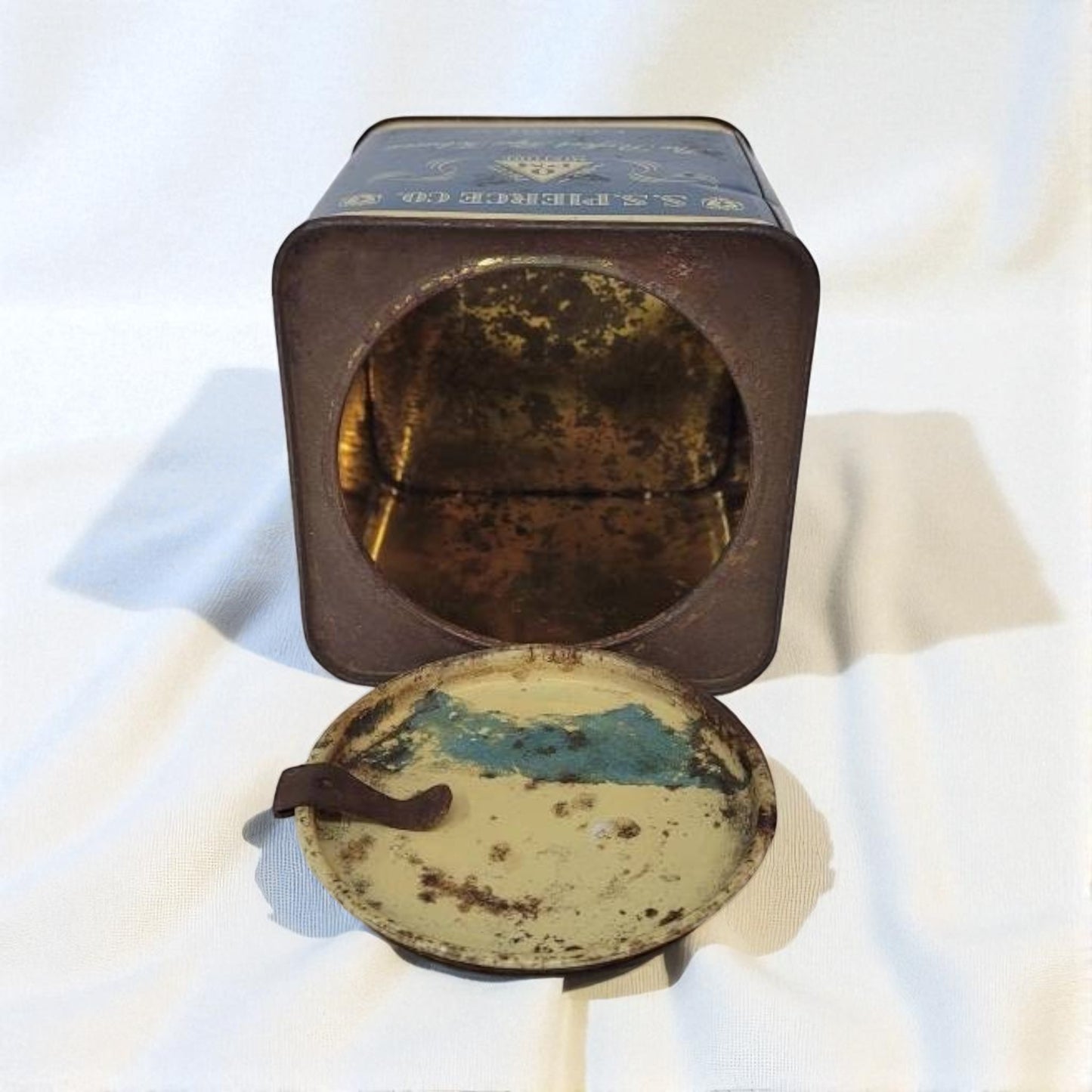 Vintage tin with a round, rusted lid on a white background