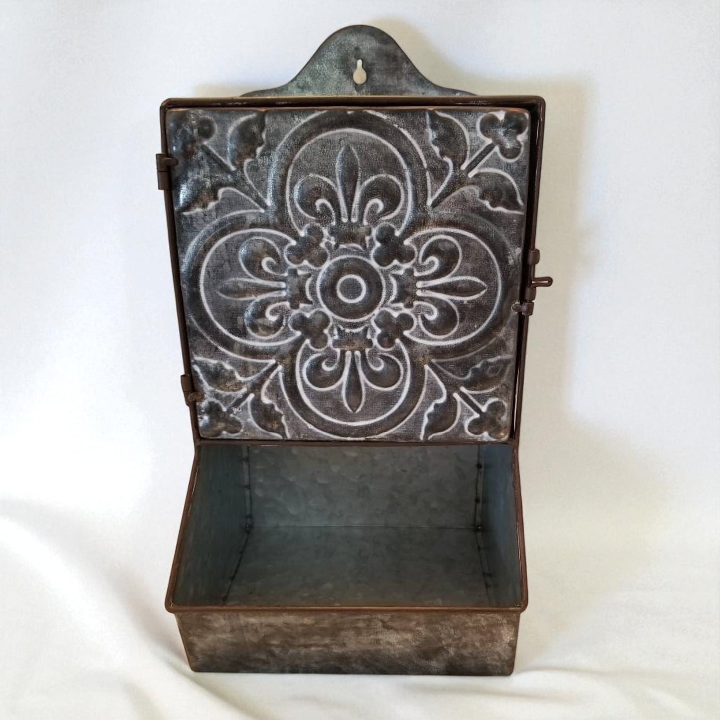 Decorative metal wall shelf with intricate patterns on a white background