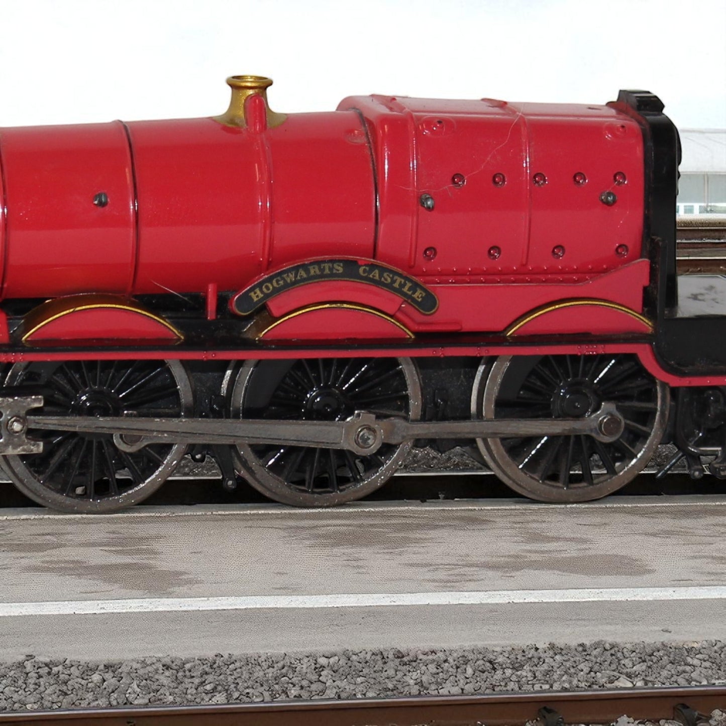 Model of a red train with 'Hogwarts Castle' on the side, on tracks.