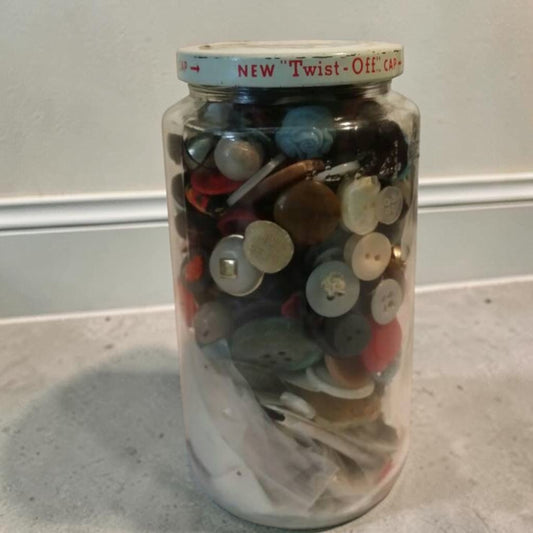 Jar full of assorted antique vintage buttons for crafting and sewing projects.