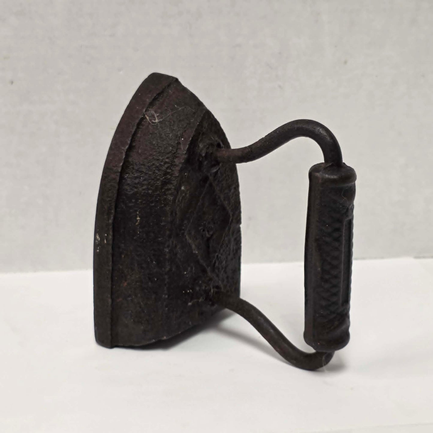 Antique Taylor Forbes No. 6 cast iron sad iron with diamond marking and patterned handle.
