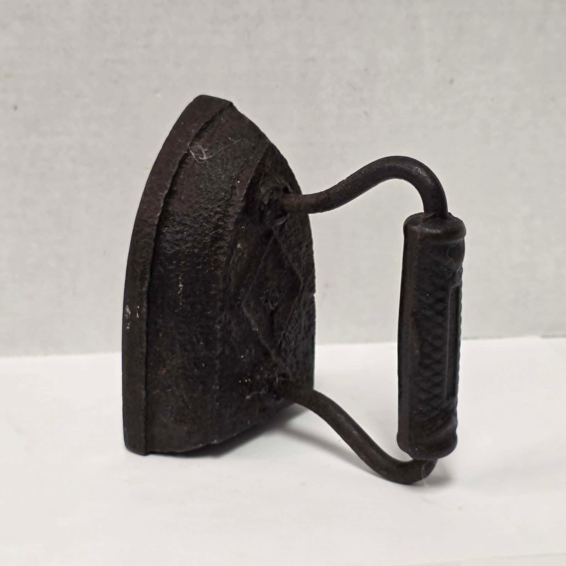 Antique Taylor Forbes No. 6 cast iron sad iron with diamond marking and patterned handle.
