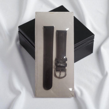 Black watch strap with silver buckle on a clear stand against a white background