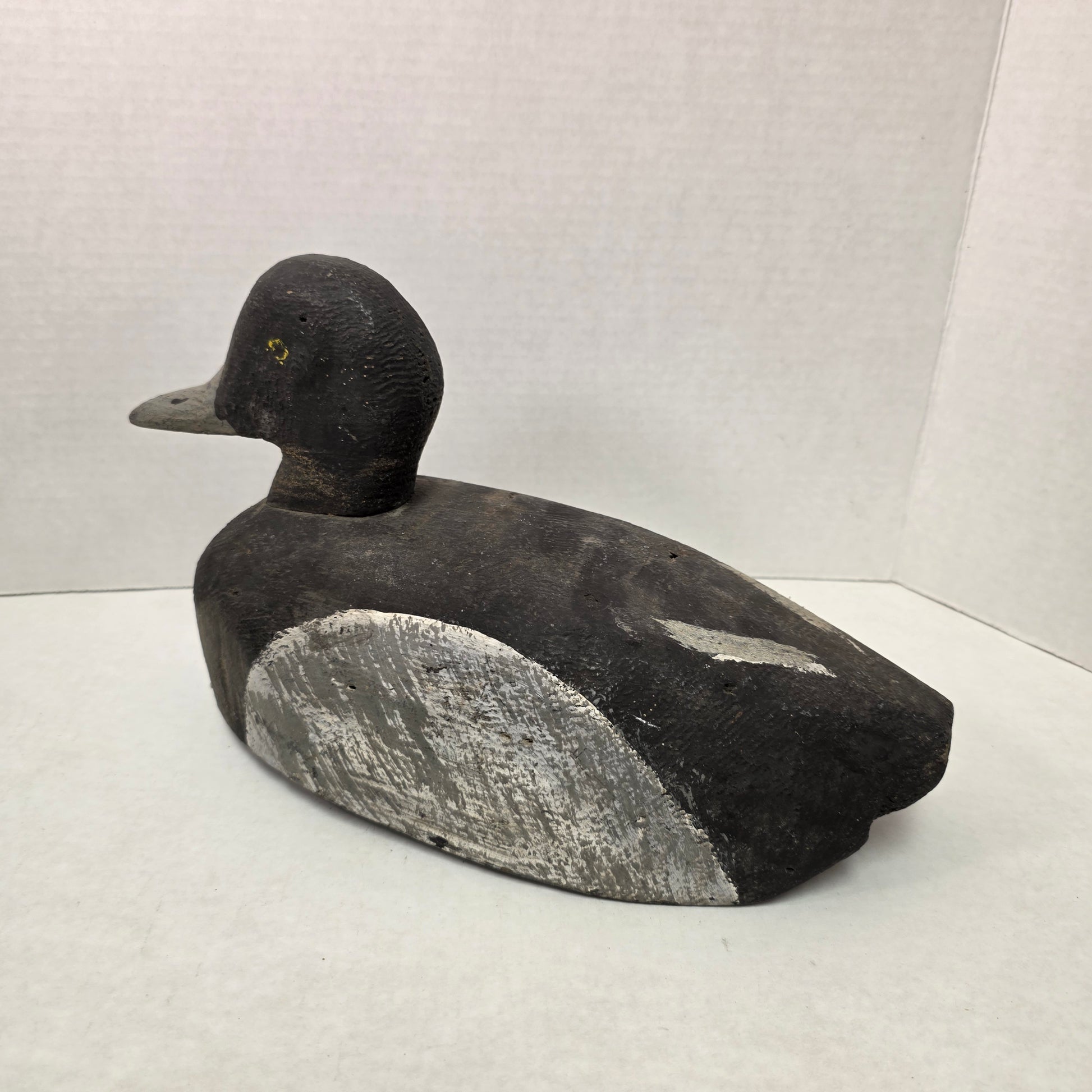 Black and gray duck decoy on a white background