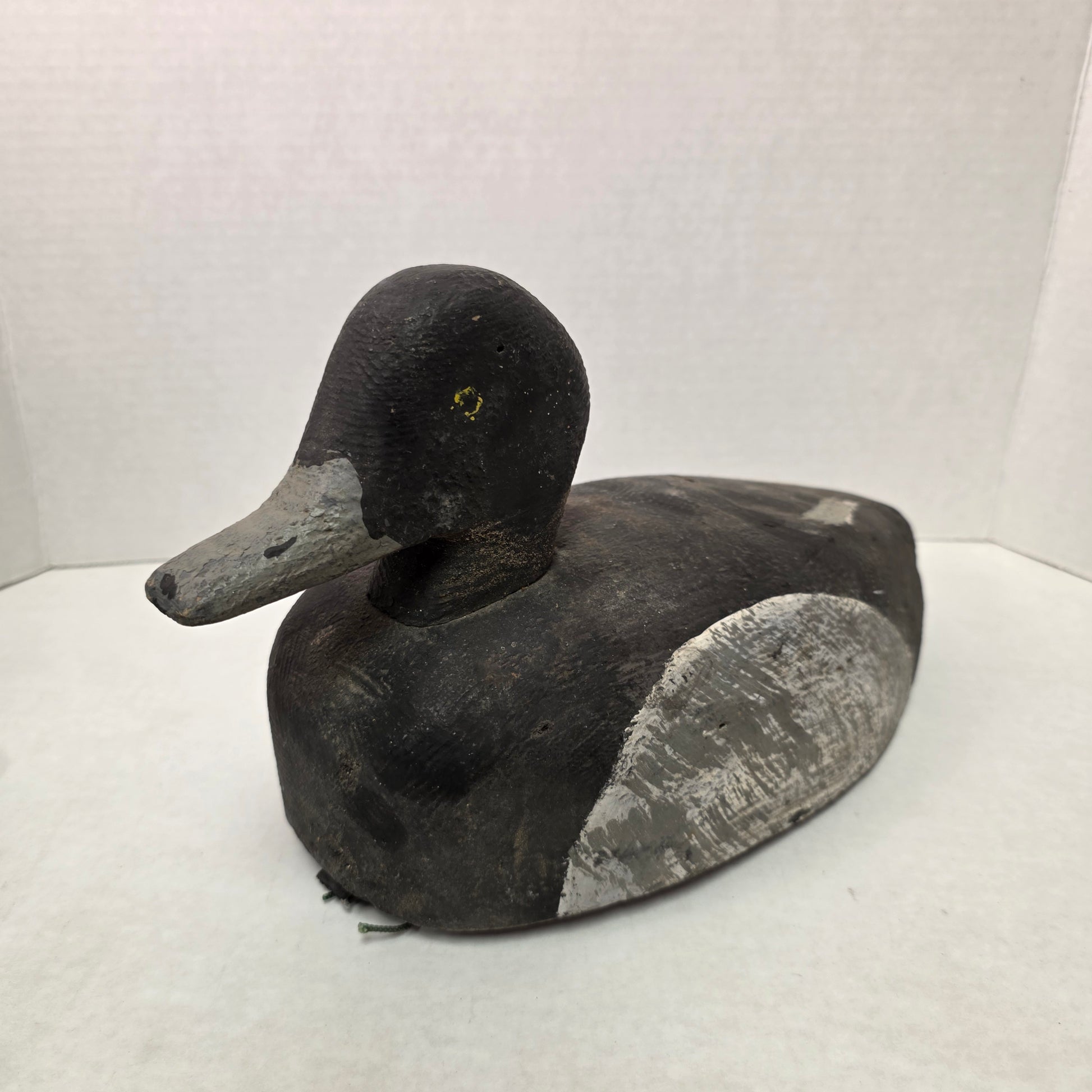 Black and gray duck decoy on a white background